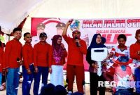 Caption: seorang ibu rumah tangga mendapatkan hadiah utama sepeda listrik, (dok. regamedianews). 