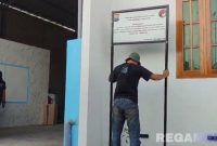 Caption: polisi tak berseragam, pasang plang penyitaan terhadap rumah oknum kades terlibat kasus TPPU dan narkoba, (dok. regamedianews). 