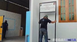 Caption: polisi tak berseragam, pasang plang penyitaan terhadap rumah oknum kades terlibat kasus TPPU dan narkoba, (dok. regamedianews). 