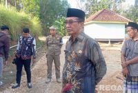 Caption: Bupati Pamekasan KH Kholilurrahman, meninjau langsung pengerjaan renovasi jalan swadaya, (dok. regamedianews). 