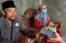 Caption: Rosyid Latif didampingi istri dan bayi yang ditemukan, saat ditemui awak media di rumahnya di Desa Astapah, (dok. regamedianews). 