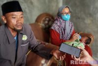 Caption: Rosyid Latif didampingi istri dan bayi yang ditemukan, saat ditemui awak media di rumahnya di Desa Astapah, (dok. regamedianews). 