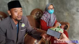 Caption: Rosyid Latif didampingi istri dan bayi yang ditemukan, saat ditemui awak media di rumahnya di Desa Astapah, (dok. regamedianews). 