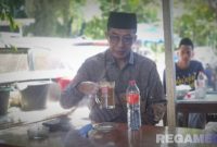 Caption: Bupati Pamekasan KH Kholilurrahman, saat ngopi di warkop sekitar rumah sakit di Kota Surabaya, (dok. regamedianews). 