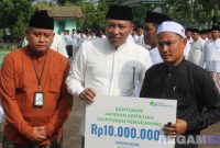Caption: didampingi Kepala BPJS Ketenagakerjaan Madura, Bupati Sampang secara simbolis menyerahkan santunan kepada ahli waris guru ngaji, (dok. foto istimewa). 