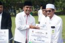 Caption: Bupati Bangkalan Lukman Hakim, menyerahkan bantuan dana insentif secara simbolis kepada guru ngaji, (dok. regamedianews). 