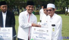 Caption: Bupati Bangkalan Lukman Hakim, menyerahkan bantuan dana insentif secara simbolis kepada guru ngaji, (dok. regamedianews). 