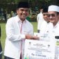 Caption: Bupati Bangkalan Lukman Hakim, menyerahkan bantuan dana insentif secara simbolis kepada guru ngaji, (dok. regamedianews). 