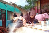 Caption: tampak kondisi atap ruang kelas SDN Madulang 2 ambruk, dan sebagian siswa belajar di rumah warga, (dok. regamedianews).