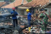 Caption: petugas damkar tampak dibantu personel TNI, memadamkan api yang menghanguskan rumah warga Desa Tambak, (dok. regamedianews).