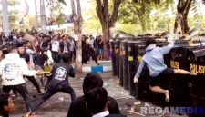 Caption: massa aksi demo DPRD Sampang mencoba merobohkan pagar pengamanan personel kepolisian, (dok. regamedianews).