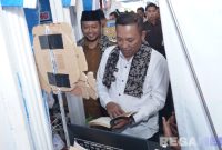 Caption: Bupati Sampang H. Slamet Junaidi, meninjau dan membaca buku di stand dalam acara Festival Literasi Sampang 2025, (sumber foto: Diskominfo Sampang). 