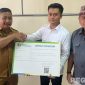 Caption: Kepala BPJS Ketenagakerjaan Cabang Madura, Indriyatno, dampingi Ketua Satgas MBG Bangkalan menyerahkan sertifikat kepesertaan kepada pekerja program MBG, (dok. foto istimewa). 