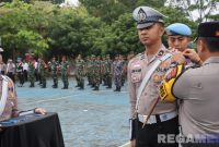 Caption: Kapolres Bangkalan AKBP Hendro Sukmono sematkan pita kepada anggotanya, tanda dimulainya Operasi Zebra Semeru 2025, (sumber foto: Humas Polres Bangkalan).