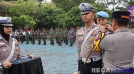 Caption: Kapolres Bangkalan AKBP Hendro Sukmono sematkan pita kepada anggotanya, tanda dimulainya Operasi Zebra Semeru 2025, (sumber foto: Humas Polres Bangkalan). 