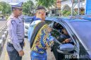 Caption: Polantas gandeng Duta Lantas Polres Sampang, membagikan brosur sosialisasi Operasi Zebra Semeru 2025 kepada pengendara, (sumber foto: Polantas Sampang). 