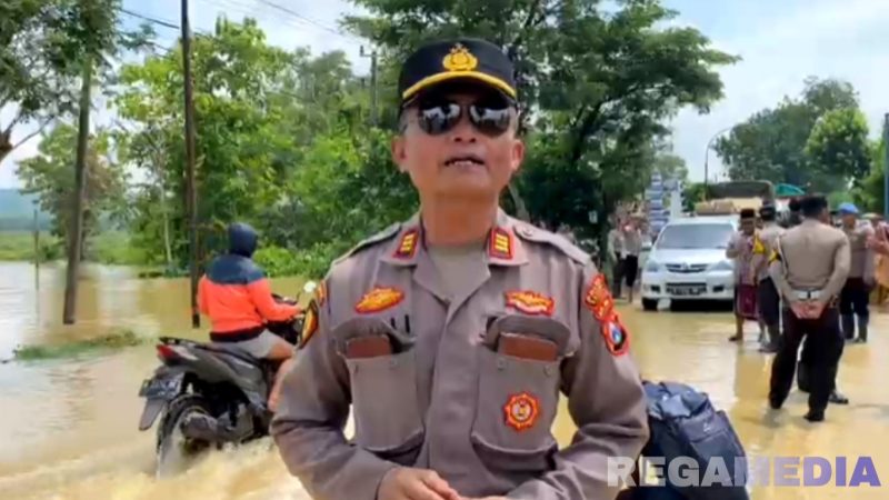 Caption: Plh Kasi Humas Polres Sampang AKP Eko Puji Waluyo, saat melaporkan kondisi banjir dan arus lalulintas di jalan raya Jrengik, (dok. regamedianews). 