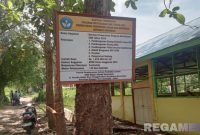 Caption: terkesan asal pasang, papan nama proyek Revitalisasi SMKN Model Gorontalo tampak terpasang di pohon, (dok. regamedianews). 