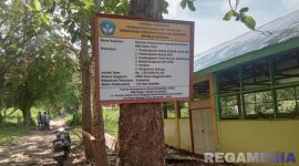Caption: terkesan asal pasang, papan nama proyek Revitalisasi SMKN Model Gorontalo tampak terpasang di pohon, (dok. regamedianews). 