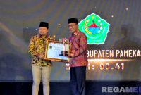 Caption: Bupati Pamekasan KH Kholilurrahman menerima piagam penghargan kabupaten terbaik dalam penerapan keterbukaan informasi publik, (dok. Kursi, Rega Media). 