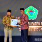Caption: Bupati Pamekasan KH Kholilurrahman menerima piagam penghargan kabupaten terbaik dalam penerapan keterbukaan informasi publik, (dok. Kursi, Rega Media). 