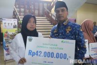 Caption: Bupati Bangkalan Lukman Hakim, secara simbolis menyerahkan santunan JKM BPJS Ketenagakerjaan kepada salah satu ahli waris anggota BPD Bangkalan, (dok. foto istimewa).