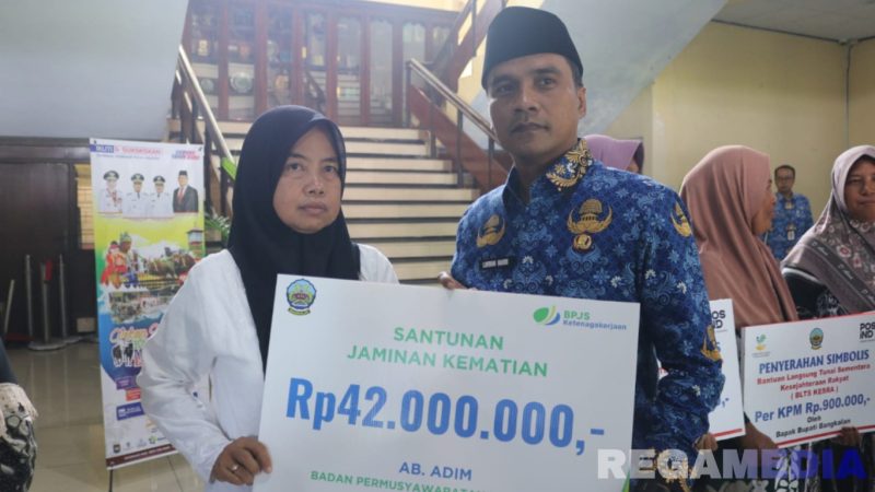 Caption: Bupati Bangkalan Lukman Hakim, secara simbolis menyerahkan santunan JKM BPJS Ketenagakerjaan kepada salah satu ahli waris anggota BPD Bangkalan, (dok. foto istimewa). 