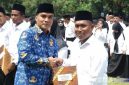 Caption: Bupati Bangkalan Lukman Hakim menyerahkan SK kepada anggota BPD usai pengukuhan, (dok. Syafin, Rega Media). 