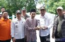 Caption: usai peresmian Jembatan Desa Daleman, Bupati Sampang H Slamet Junaidi memberikan potongan tumpeng kepada salah satu tokoh agama desa setempat, (sumber foto: Diskominfo Sampang). 