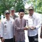Caption: usai resmikan Jembatan Desa Daleman, Bupati Sampang H Slamet Junaidi memberikan potongan tumpeng kepada tokoh agama desa setempat, (sumber foto: Diskominfo Sampang). 
