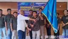 Caption: Wakil Ketua PWI Jatim serahkan bendera pataka PWI Bangkalan kepada Mahmud Ismail, (dok. foto istimewa).