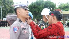 Caption: Bupati Sumenep Achmad Fauzi Wongsojudo, sematkan pita kepada anggota Polantas tanda dimulainya Operasi Lilin Semeru 2025, (sumber foto: Sumenep.go.id).
