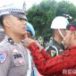 Caption: Bupati Sumenep Achmad Fauzi Wongsojudo, sematkan pita kepada anggota Polantas tanda dimulainya Operasi Lilin Semeru 2025, (sumber foto: Sumenep.go.id). 