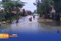 Caption: tampak sejumlah pengendara menerobos genangan banjir di jalan raya Desa Panggung, (sumber foto: BPBD Sampang). 