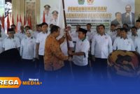 Caption: Ketua KONI Jawa Timur menyerahkan bendera pataka kepada Ketua KONI Pamekasan periode 2025-2029, (dok. Kurdi Rega Media). 