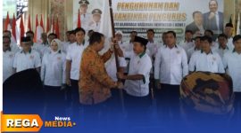 Caption: Ketua KONI Jawa Timur menyerahkan bendera pataka kepada Ketua KONI Pamekasan periode 2025-2029, (dok. Kurdi Rega Media). 