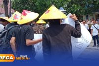 Caption: memakai topi ala petani, sejumlah mahasiswa saat aksi demo di depan Kantor Disperta-KP Sampang, (dok. Harry Rega Media). 
