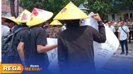 Caption: memakai topi ala petani, sejumlah mahasiswa saat aksi demo di depan Kantor Disperta-KP Sampang, (dok. Harry Rega Media). 