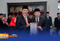 Caption: pose dengan Bupati H.Slamet Junaidi, Kepala Dinas Pendidikan Kabupaten Sampang Nor Alam tunjukkan SK, (sumber foto: Prokopim Pemkab Sampang). 