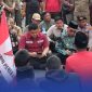 Caption: Bupati Pamekasan KH. Kholilurrahman saat menemui massa aksi demo dari GMNI di depan Kantor Pemkab Pamekasan, (dok. Kurdi Rega Media). 
