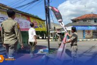 Caption: sikap tegas, petugas Satpol PP Sumenep tampak menurunkan spanduk yang tidak sesuai penempatannya, (sumber foto. Media Center Sumenep). 