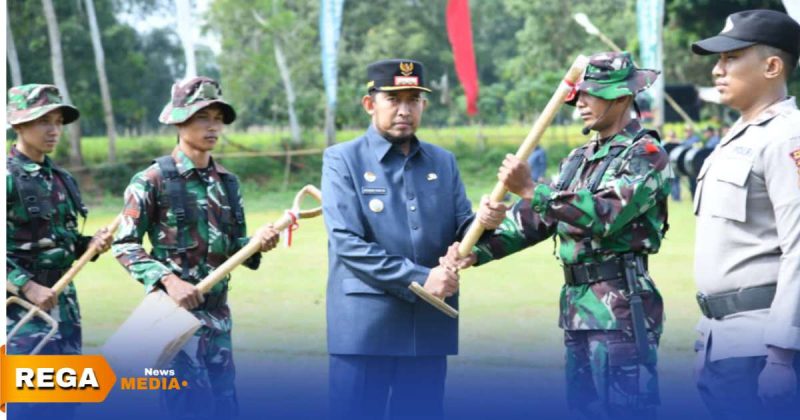 Caption: Bupati Sumenep Achmad Fauzi menyerahkan cangkul secara simbolis kepada anggota TNI, sebagai tanda di mulainya program TMMD ke-127, (sumber foto. Media Center Sumenep). 
